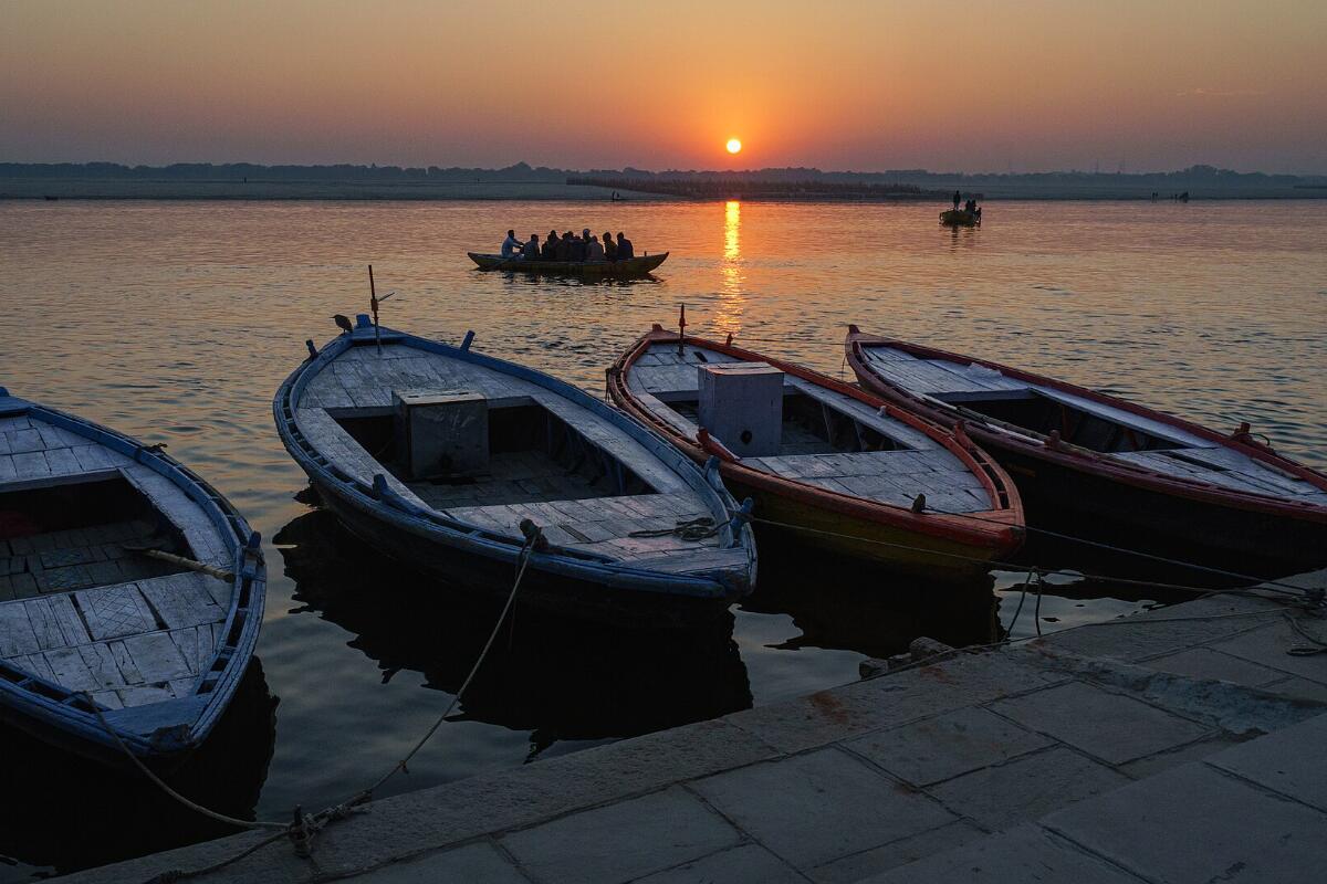 Wooden boats moored on the ghats of the Ganga at sunrise in Varanasi