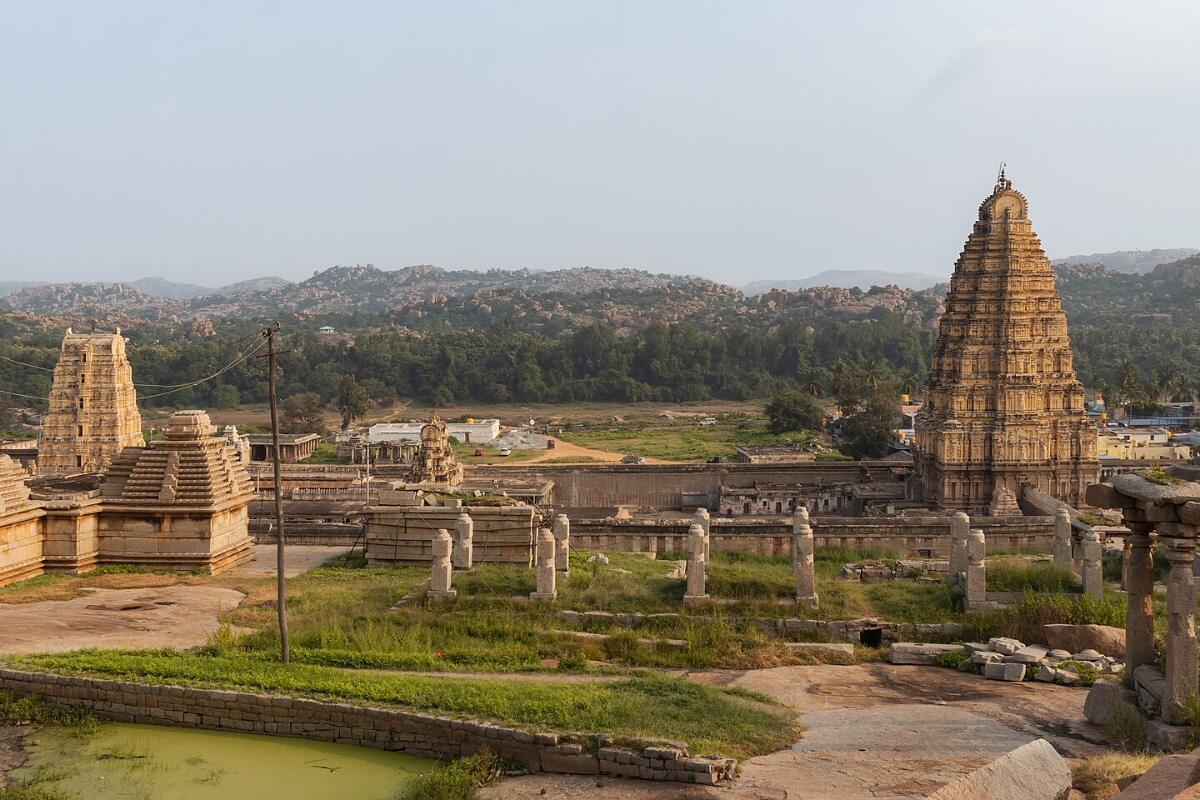 The tall gateway tower of Virupaksha Temple rising over the ruins of Hampi