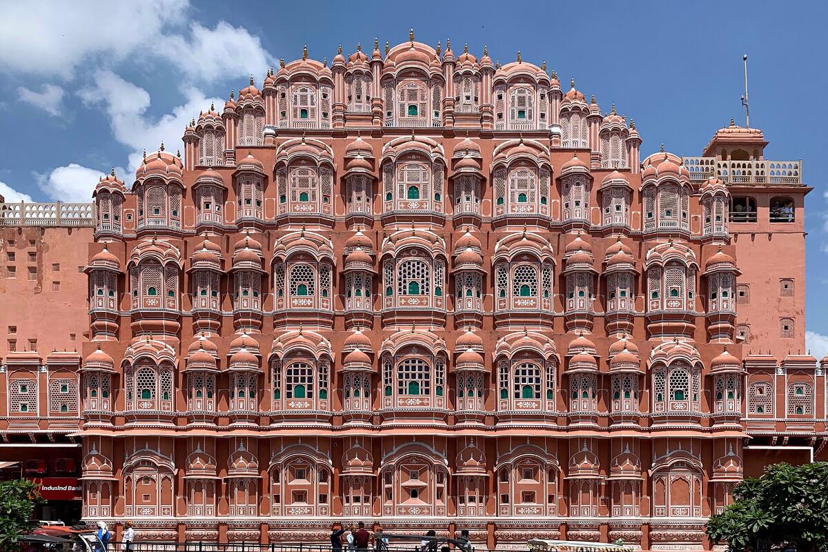 The honeycomb façade of the Hawa Mahal in Jaipur against a blue sky